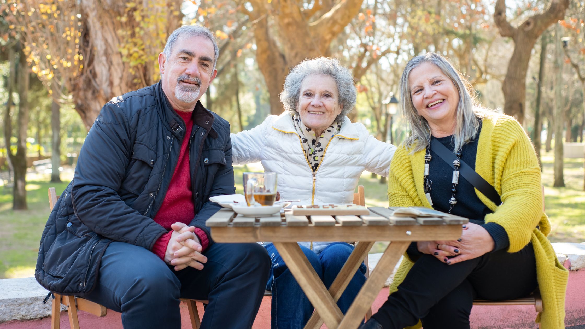Seniorzy na ławce w parku, piją herbatę